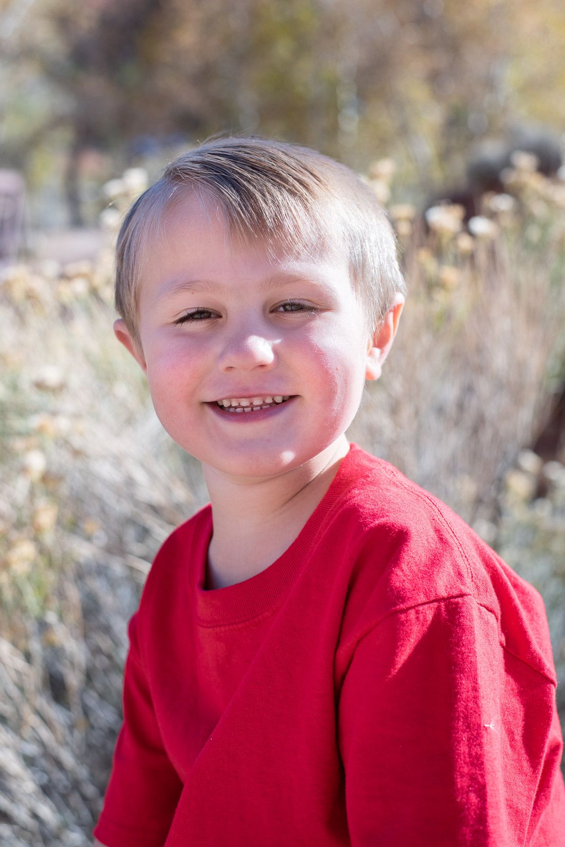Boy in red shirt looks at camera and smiles-Bethany Allen Photography