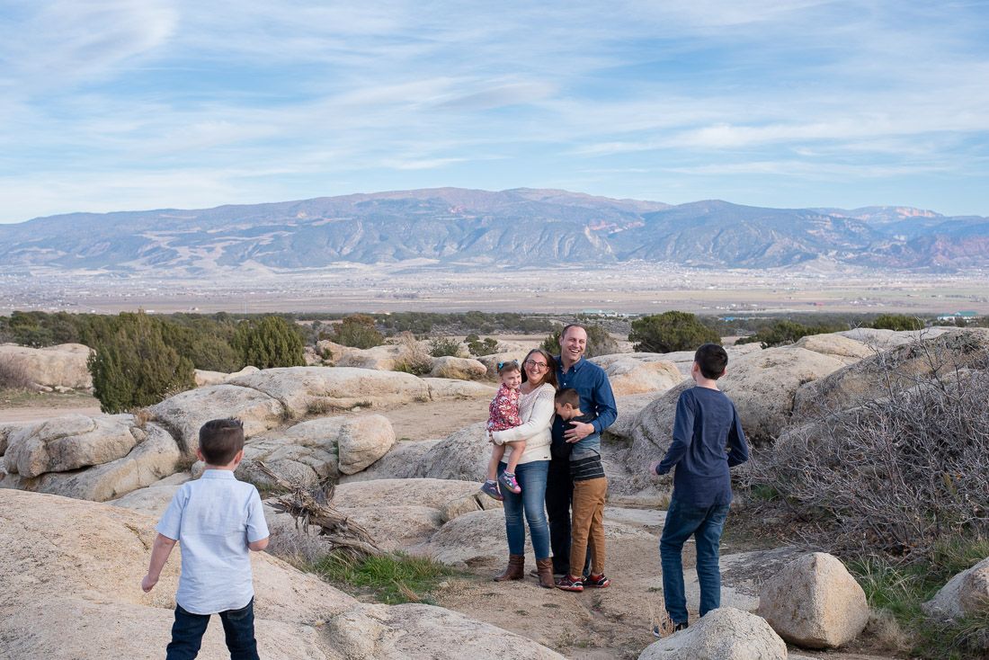 Family playing together in a rocky area overlooking Cedar City, Utah-Bethany Allen Photography