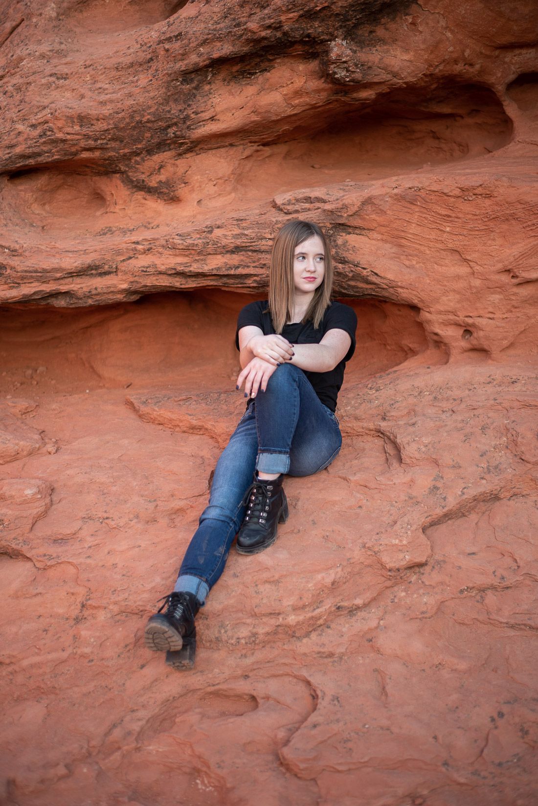 Girl sitting on red rocks