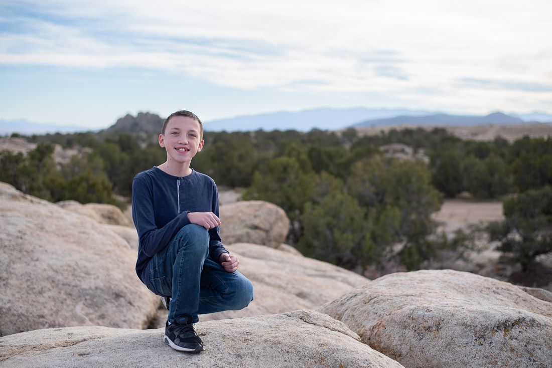 Tween boy looking at camera while kneeling down-Bethany Allen Photography