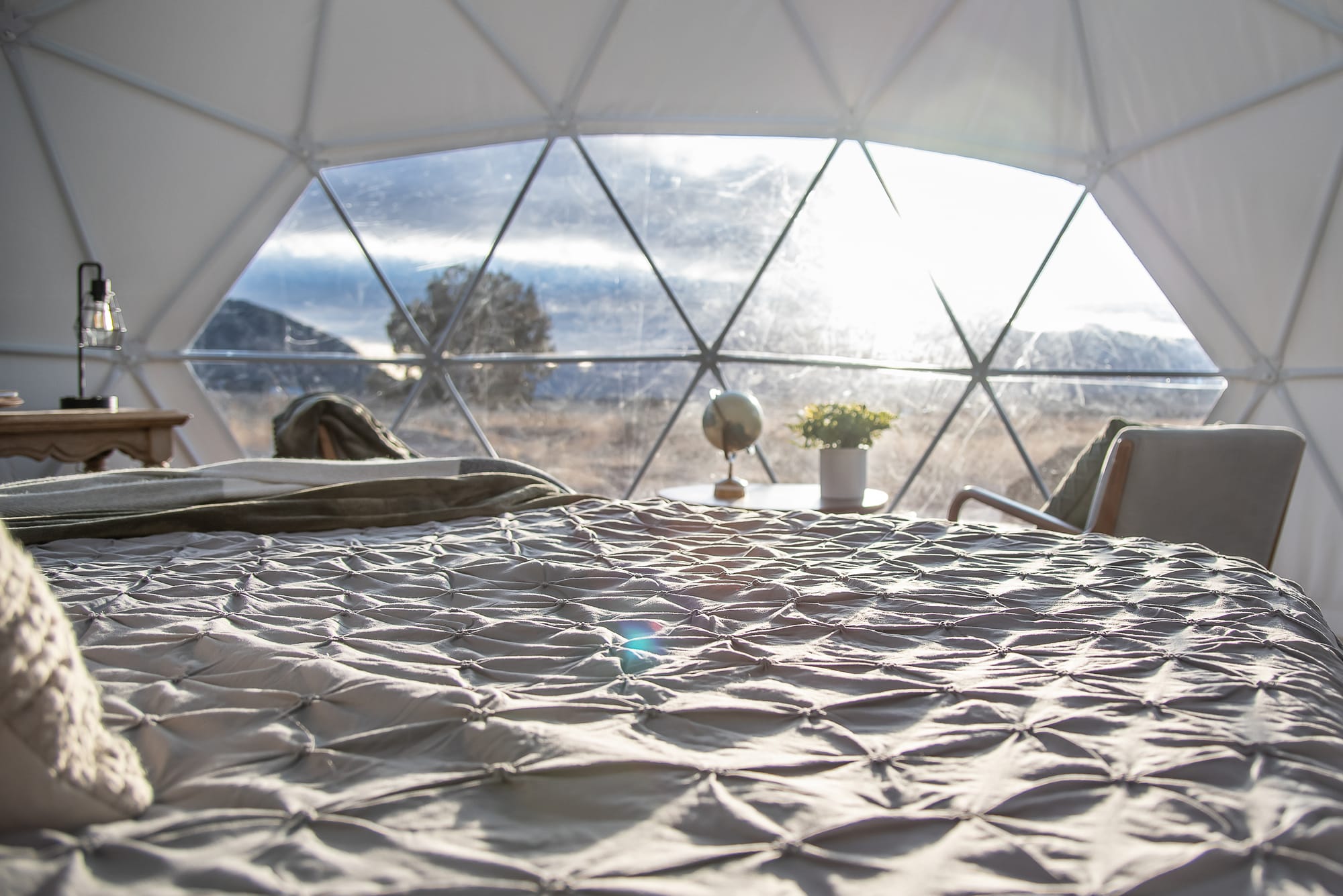 sunshine streaming through the geodesic window onto a bed